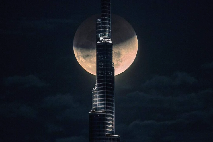 Full supermoon rising behind the Burj Khalifa at night, Dubai